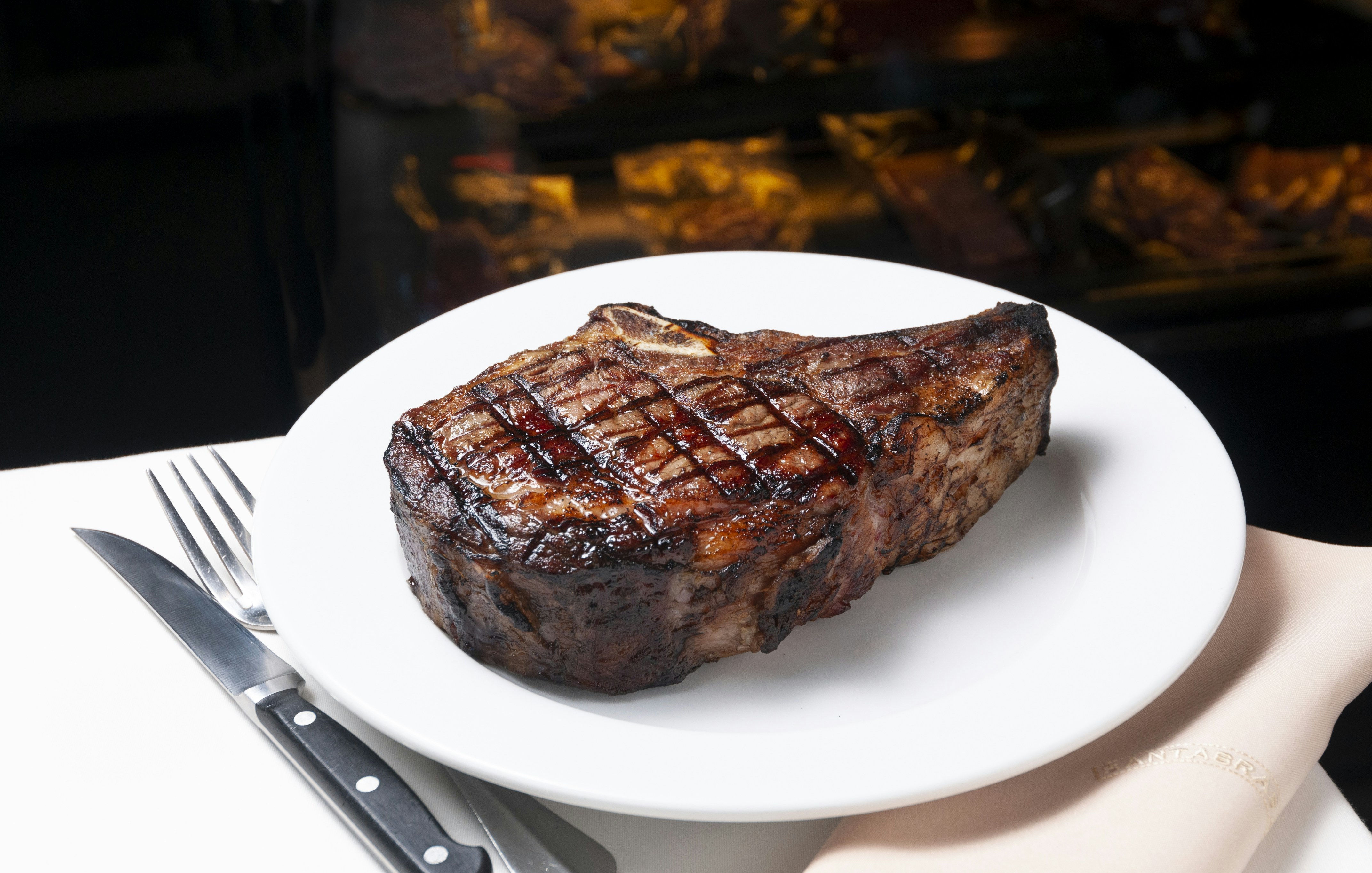 a steak on a plate with a fork and knife